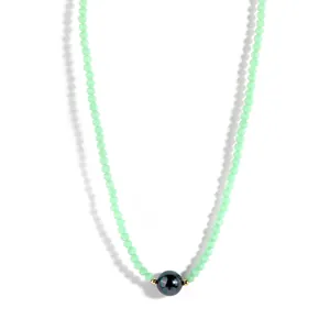Detail of beaded choker necklace featuring green faceted beads and iridescent pearl charm