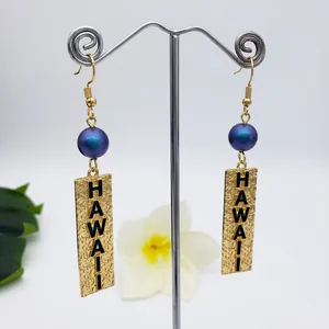 Hawaiian style gold hook earrings featuring blue shell pearls and HAWAII engraved pendants