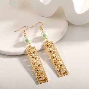 Detail of gold-plated drop earrings with light green pearl and hollow clover patterns