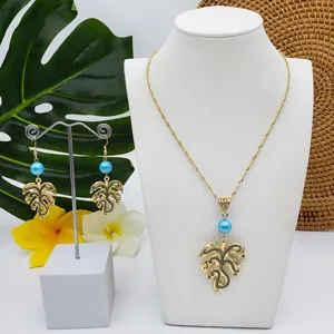 Detail of Monstera leaf jewelry set with blue beads on white mannequin and display stand