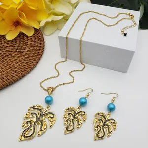 Detailed view of Hawaiian monstera leaf jewelry set with gold alloy and blue beads