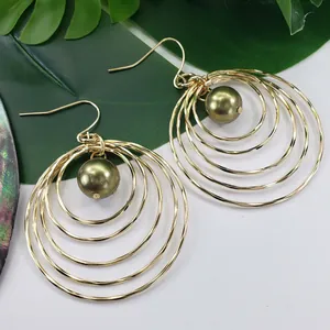 Detailed view of bohemian gold multilayer hoop earrings with dark green pearl accents