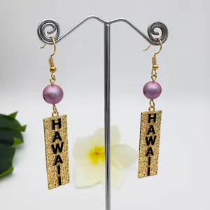 Detail of Hawaii engraved golden rectangular tag and purple pearl droplet earring