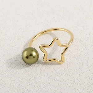 Makroaufnahme minimalistischer Ring mit hohlem Stern und olivgrüner Perle im Detail