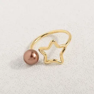 Detailaufnahme eines hohlen Sterns und einer Perle an einem goldenen offenen Ring