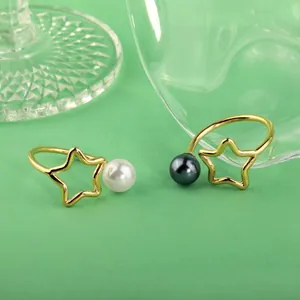 Detail der minimalistischen Stern- und Mondringe mit weißen und grauen Naturperlen
