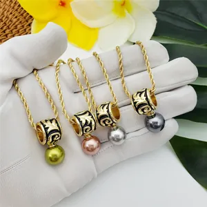 Detailed view of cylindrical enamel pendants with vintage gold carvings and colorful pearls