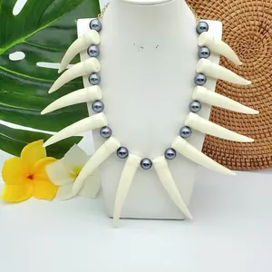 Collier tribal avec pendentifs en corne blanche et perles sur fond de style tropical