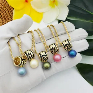 Detail of colorful pearl necklaces with golden Hawaiian totem charms held in hand