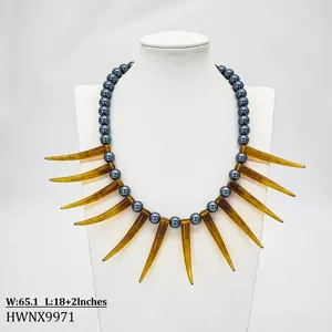 Détail d'un collier de perles tribal avec pointes de corne ambrées sur mannequin