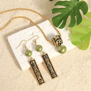 Detail of Polynesian totem jewelry set with green beads and gold embossed patterns