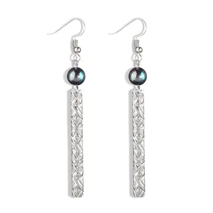 Macro detail of silver drop earrings with iridescent shell pearl and scrolled metal bar