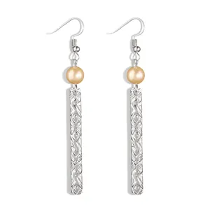 Detail view of silver drop earrings with floral embossed bars and champagne pearls