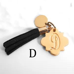 Detailed macro view of golden alphabet D pendant with elegant black tassel keychain