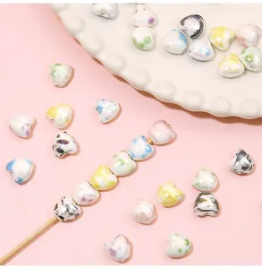 Macro shot of heart-shaped pearl beads with colorful ink marbling for DIY jewelry