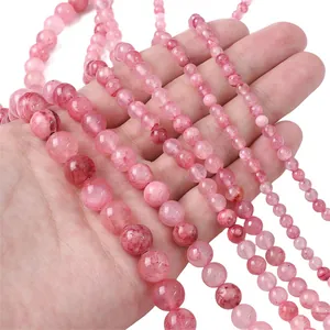 Dettaglio di perle di giada persiana rosa in varie dimensioni per la creazione di gioielli