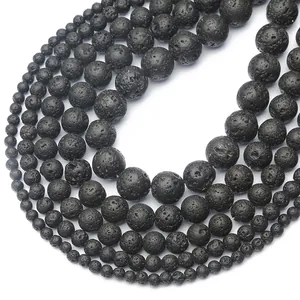 Macro shot of various sizes of porous black lava stone round beads for DIY jewelry making
