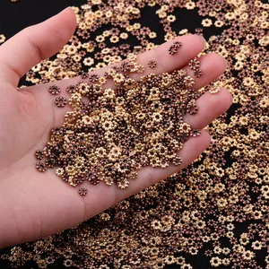 Alloy flower spacer beads for DIY jewelry in gold and bronze finish on hand