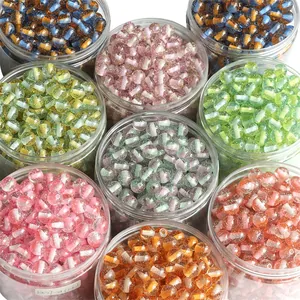 Macro shot of colorful glitter resin beads in a clear container for DIY jewelry making