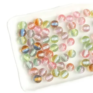 Colorful striped resin beads with glitter for DIY jewelry making in a white ceramic dish