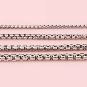 Polished stainless steel box chains in four different widths on a pink background