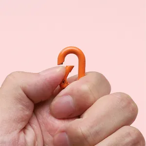 Macro detail of flexible orange spring carabiner hook for DIY keychain accessories