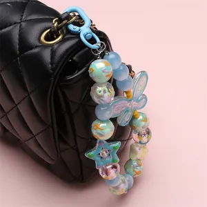 Detail of colorful macaron bead bag charm with butterfly and star on quilted leather