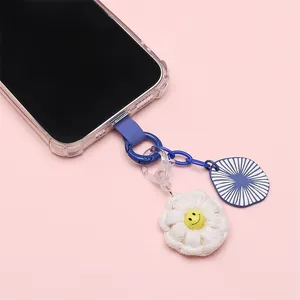Detail of navy velvet phone tether tab with crochet daisy charm and blue link chain