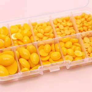 Flatback acrylic oval doll eyes in yellow for DIY crafts stored in a clear organizer box