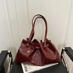Sac fourre-tout plissé en cuir rouge foncé pour femme posé sur une chaise
