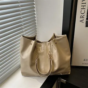 Chic beige large capacity leather tote bag with elegant chain shoulder strap and stitching