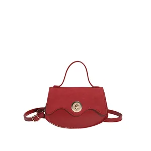 Borsa a mano retrò rossa con cuciture in pelle scamosciata e fibbia dorata su sfondo bianco