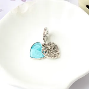 Dettaglio del charm cuore in smalto blu e ciondolo cuore traforato con micro zirconi