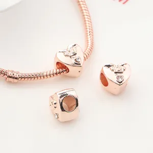 Makro-Detail von herzförmigem Anhänger in Roségold mit Krone und Kristall auf Armband
