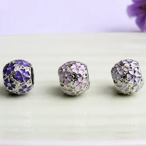 Detailed view of cherry blossom enamel charms in purple, pink and white with crystals