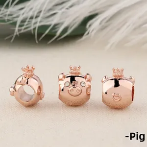 Detailed macro of three rose gold pig charms with crowns and rhinestones for DIY bracelets