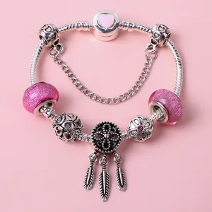 Pink heart charm bracelet with glass beads and dreamcatcher pendant on pink background