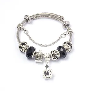 Detail van DIY roestvrijstalen bedelarmband met zwarte facetkralen en kroonhanger