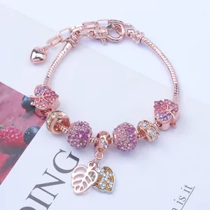 Detailansicht eines roségoldenen Schlangenarmbands mit lila Kristallanhängern und Blättern