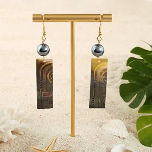 Boucles d'oreilles dorées avec perles sombres et pendentif en nacre noire gravée chic