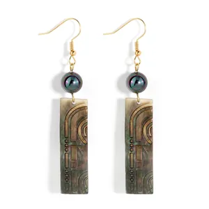 Vue détaillée de longues boucles d'oreilles pendantes en nacre noire et crochets dorés