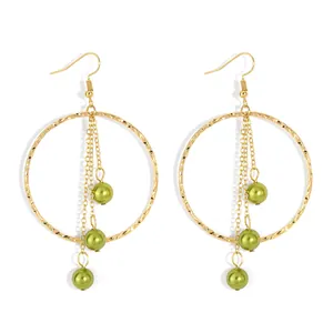Elegant gold hoop earrings with green pearl tassels and hammered finish in minimalist style