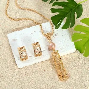 Parure de bijoux hawaïens avec collier perle rose et boucles d'oreilles dorées ajourées