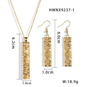 Gold bamboo bar jewelry set with necklace and earrings featuring tropical floral engraving