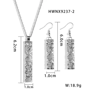 Detailed view of silver bamboo pendant necklace and earrings set with floral engraving