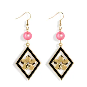 Boucles d'oreilles dorées avec perles roses et breloques losanges en émail noir fleuri