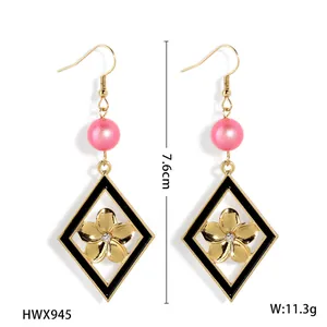 Boucles d'oreilles losange dorées élégantes avec émail noir, perle et fleur d'or