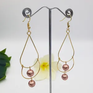 Golden double-layered teardrop earrings with pink pearls and elegant fishhook design