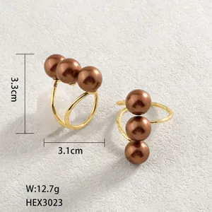 Dettaglio orecchini placcati oro 14k di 3,3 x 3,1 cm con tre perle marroni incastonate