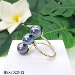 Dettaglio di tre perle di conchiglia grigio scuro su anello aperto placcato oro 14k